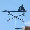 Sailing Boat Weathervane A Black Fox Metalcraft Ltd Sailing Boat Weathervane elegantly perches on the roof, its sleek design indicating N, S, E, W against the clear blue sky.
