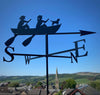 Rowing Boat Weathervane The Rowing Boat Weathervane by Black Fox Metalcraft Ltd features two people and a dog paddling a boat above a town scene with hills and a church, finished with zinc electroplate for extra durability.