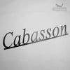 Laser Cut Metal Sign The Laser Cut Metal Sign by Black Fox Metalcraft Ltd features "Cabasson" in a black serif font, mounted diagonally on a white wall, with the Black Fox logo—perfect for those seeking elegant custom metal signs.