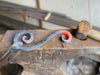 Forged metal scroll cooling on our anvil.