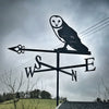 Barn Owl Weathervane mounted to a small shed with a dark stormy sky background.