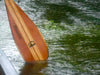 Canoe paddle in water, with bespoke branding iron logo visible