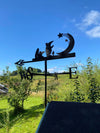 A unique clangers weathervane on a summerhouse roof, with stunning summer blue sky.