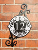 Metal art house number sign based around the theme of climbing roses.