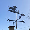 Weathervane with dachshund silhouette against a clear blue sky