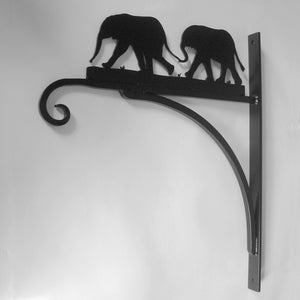 The Elephants Hanging Basket Bracket by Black Fox Metalcraft Ltd is a black metal bracket featuring elephant silhouettes, ideal for custom designs or as a unique piece celebrating African wildlife.