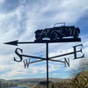 A classic car enthusiast's dream, the Jaguar SS100 Weathervane by Black Fox Metalcraft Ltd features a vintage silhouette with directional letters set against a cloudy sky.