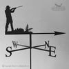 The depiction shows the silhouette of a person aiming at a Shooting Weathervane, which features cardinal directions SW, W, NE, and E. Nearby fern leaves provide a natural accent. The Black Fox Metalcraft Ltd logo in the corner guarantees rust protection.