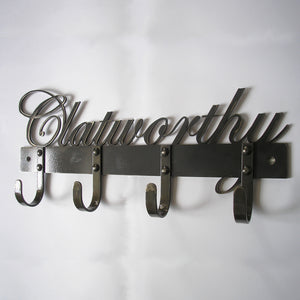 The Black Fox Metalcraft Ltd Industrial Style Coat Hooks feature four sturdy riveted hooks, perfect for dog leads, with “Clatworthy” elegantly written in cursive above the hooks.