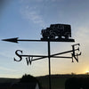 Set against the backdrop of a winter sunrise sky, the Black Fox Metalcraft Ltd Landrover Series 1 Weathervane features a silhouette design with clearly visible directional letters: N, S, E, and W.