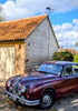 Mark 2 jag weathervane mounted to an oak garage, with the car itself in the foreground.