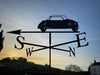 A silhouette of the Messerschmitt Weathervane crafted by Black Fox Metalcraft Ltd, intricately designed to point towards cardinal directions against a sunset sky, perfect for classic car enthusiasts.