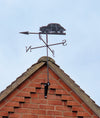 Morris Minor weathervane mounted to a brick gable end.