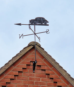 Morris Minor weathervane mounted to a brick gable end.