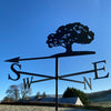Oak Tree weather vane photographed with a bright blue winter sky background.