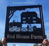 Personalised Hanging Farm Sign from Black Fox Metalcraft Ltd, showcasing a tractor, farmhouse, and "Red House Farm" text against a blue sky, mounted on a hand-forged bracket.