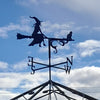 The Witch and Cat Weathervane by Black Fox Metalcraft Ltd features a silhouette of a witch on a broomstick with her cat, set above north, south, east, and west markers.