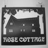 Custom hanging house sign featuring a thatched cottage